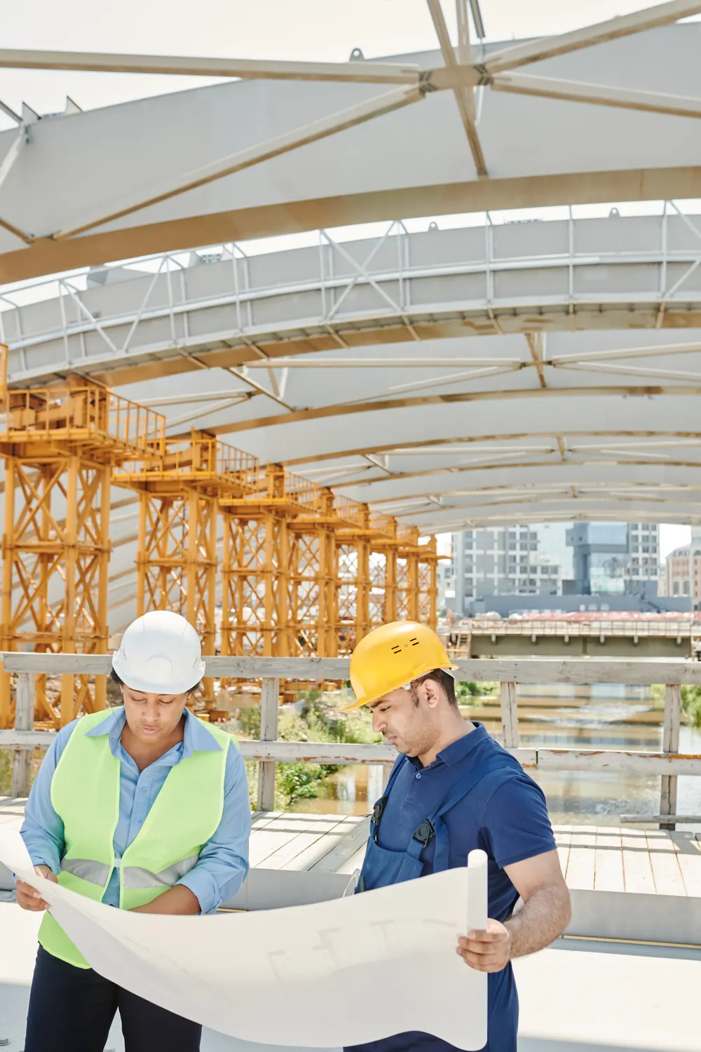 Engineers reviewing construction drawings at an active building site