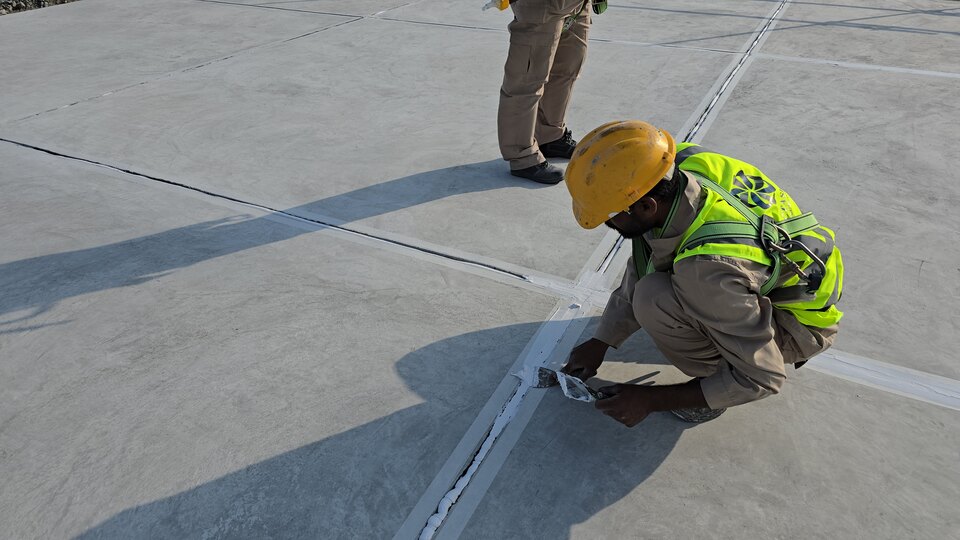 Worker filling a roof joint with sealant