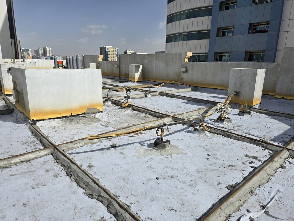 Waterproofing work across a rooftop with raised service upstands