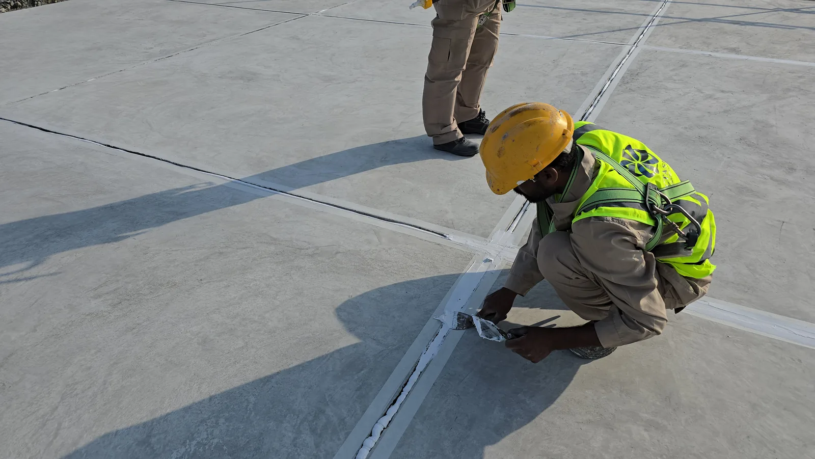 Worker filling a roof joint with sealant