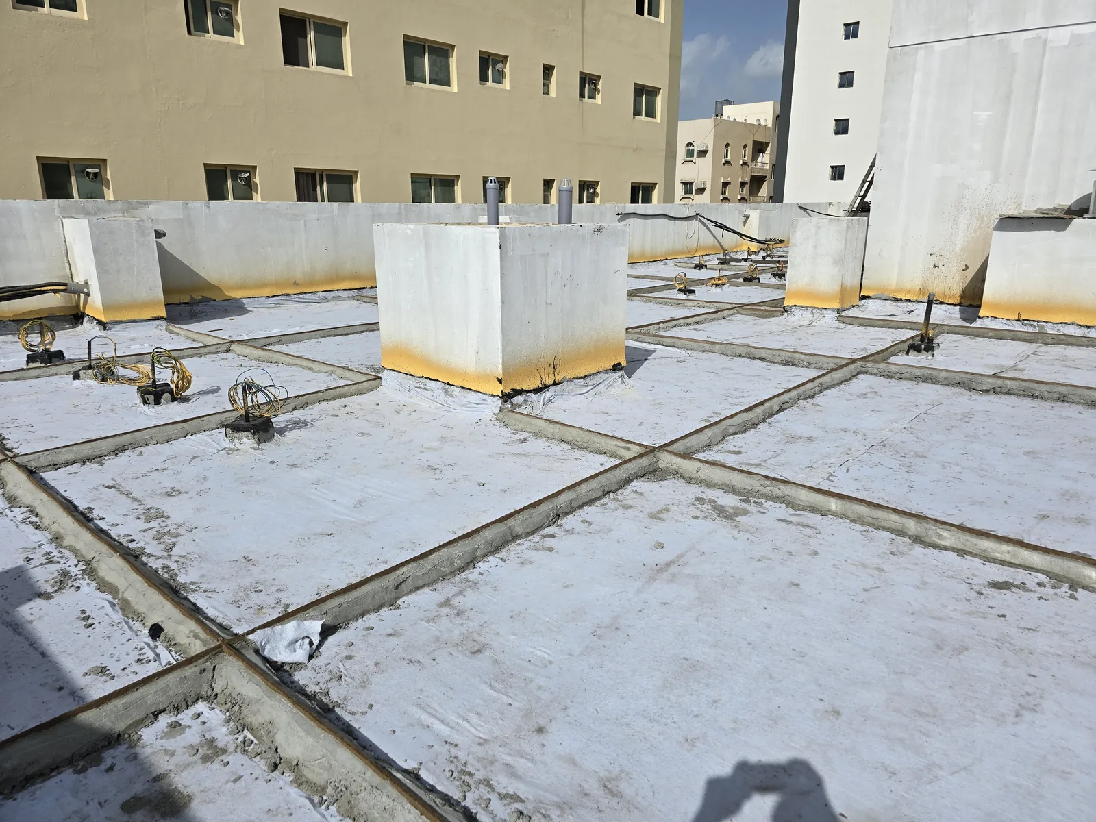 Rooftop waterproofing around raised concrete service bases