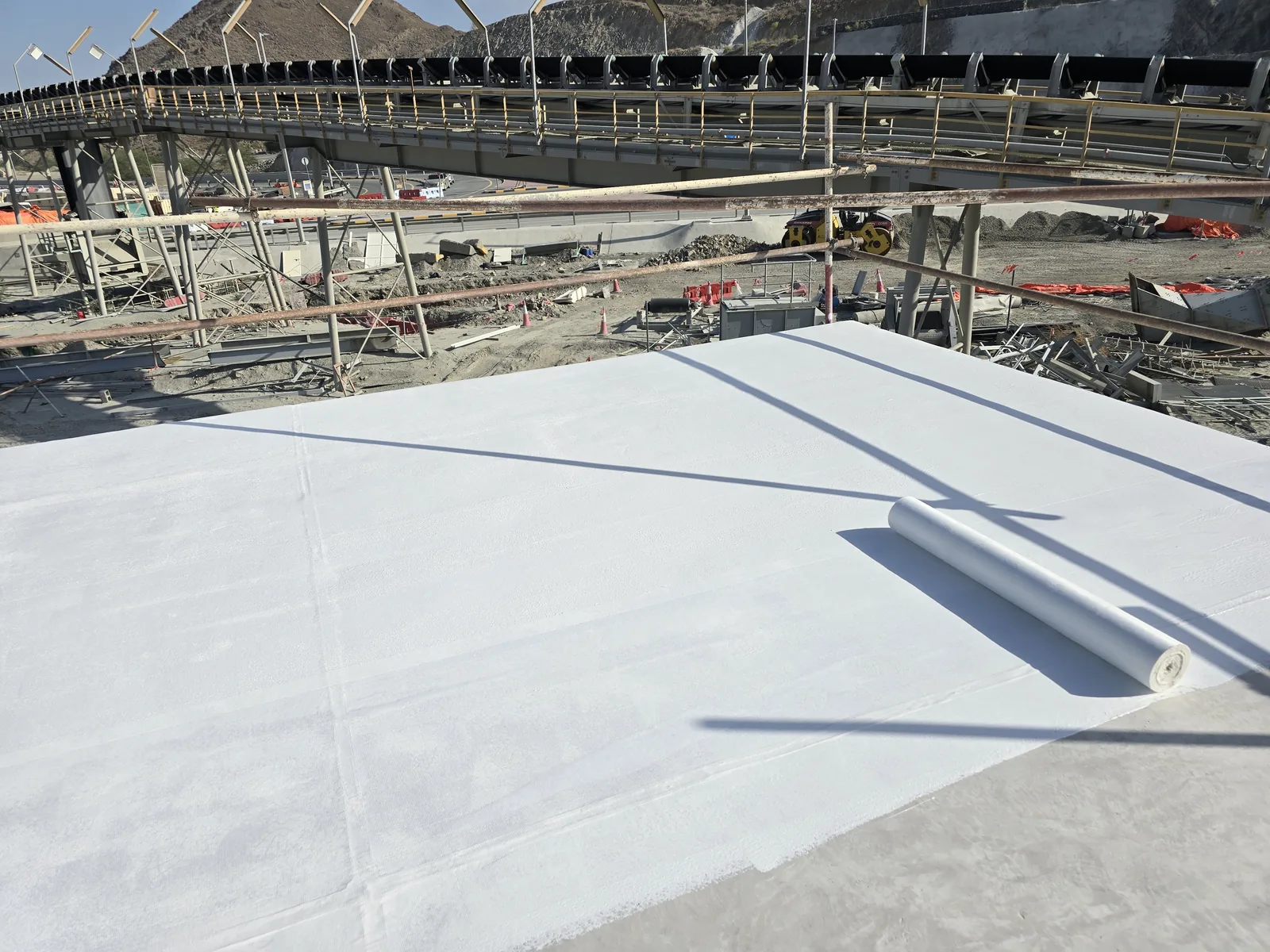 Broad rooftop surface with perimeter parapet and service details