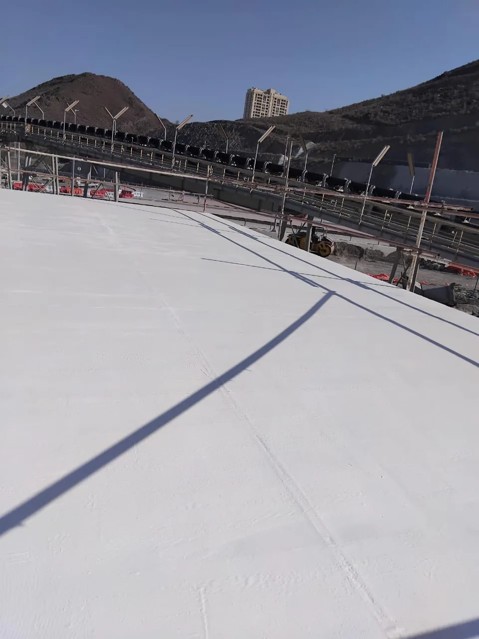 Rooftop waterproofing surface beside a perimeter upstand